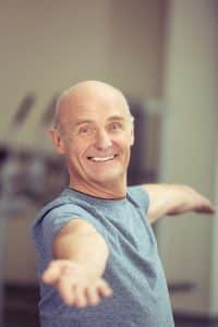 Happy elderly man working out doing exercises