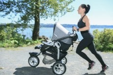 Young mother jogging with a baby buggy