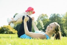 A mother training with baby on a summer day