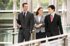 Three Business Colleagues Having Discussion Whilst Walking Outside Office