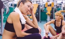 Woman tired with towel resting in the gym after training