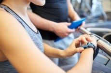 close up of woman setting heart-rate watch at gym