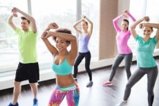group of smiling people dancing in gym or studio