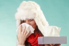Sick woman sneezing in tissue. Winter cold.