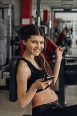 Beautiful girl with a phone in the gym
