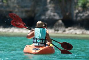 traveler kayaking in the thai ocean from backward view