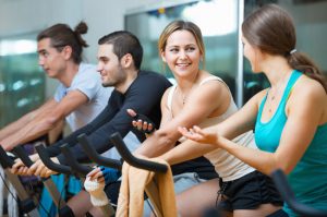 Group smiling  working out of cycling in modern fitness club