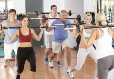 Group Of People Lifting Weights In Gym