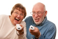 Happy Senior Couple Play Video Game with Remote Controls On a White Background.