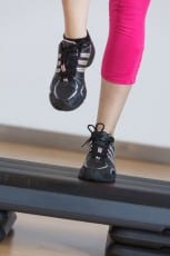 Close up of feet in step equipment at gym