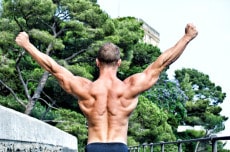 Muscular bodybuilder with hands up for victory