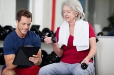 Trainer instructing a senior woman in the gym