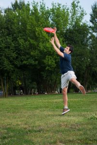 young man catching frisbee outdoors