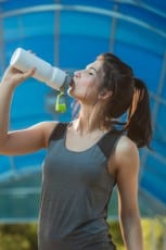 Woman drinking water sweating exercising