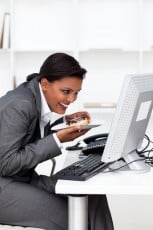 Young ethnic businesswoman eating a pastry