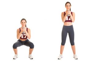 Personal Trainer doing dumbbell squat for training his legs, isolated in white