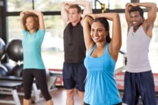 Multi-ethnic group stretching in a gym