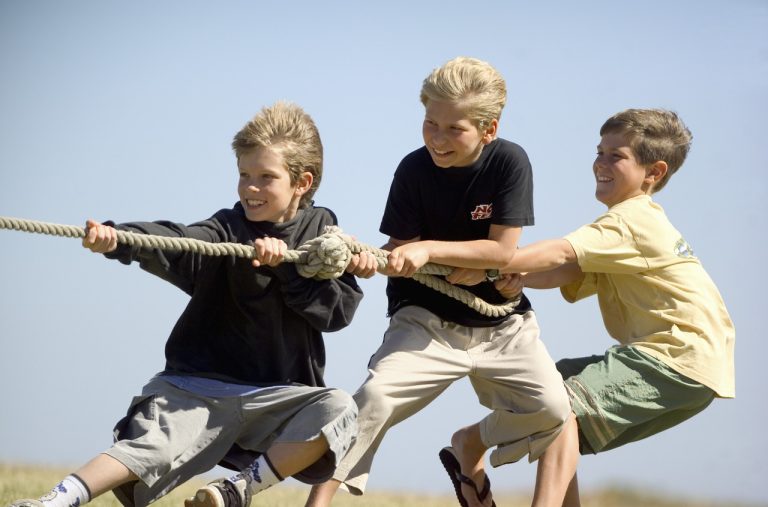 Three boys playing tug-of-war