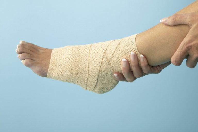Woman Holding Bandaged Ankle