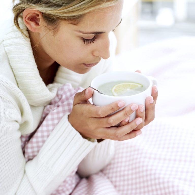 Woman Holding Cup of Water and Lemon