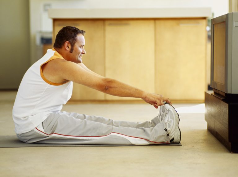 side profile of a mid adult man exercising on the floor
