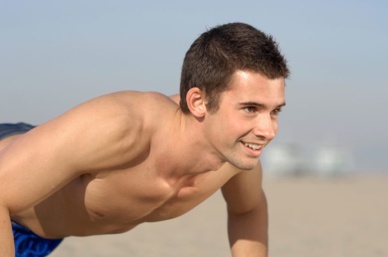 Handsome guy doing push-ups on Santa Monica Beach
