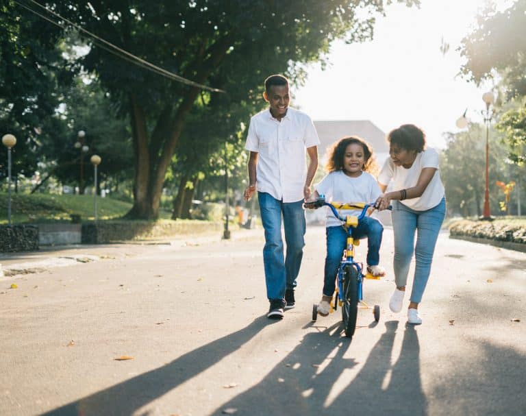 man-standing-beside-his-wife-teaching-their-child-how-to-1128318
