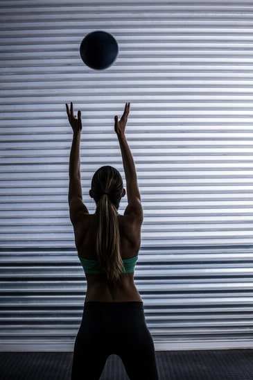 photodune-12075204-back-view-of-a-muscular-woman-throwing-ball-in-the-air-xs