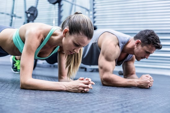 photodune-12570042-side-view-of-a-muscular-couple-doing-planking-exercises-xs