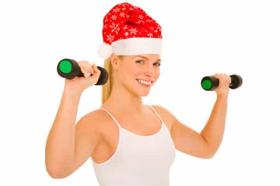 woman with Santa Hat lifts weights