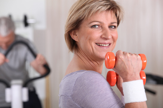 Woman using dumbbells in a gym