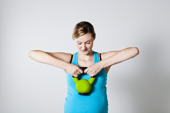 Pregnant woman exercising with kettlebell