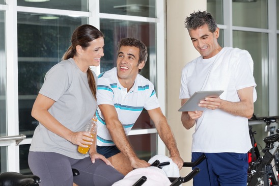 Friends Using Digital Tablet In Gym