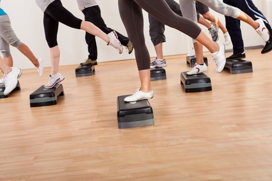 Class doing aerobics balancing on boards