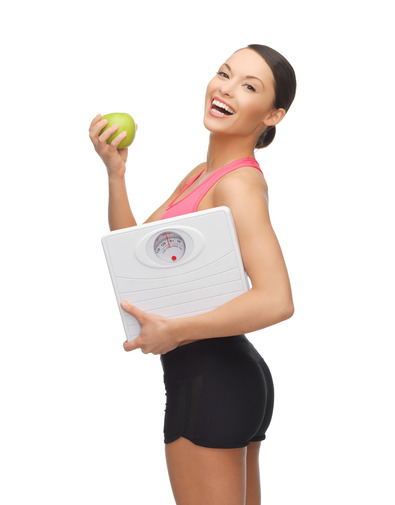 sporty woman with scale and green apple