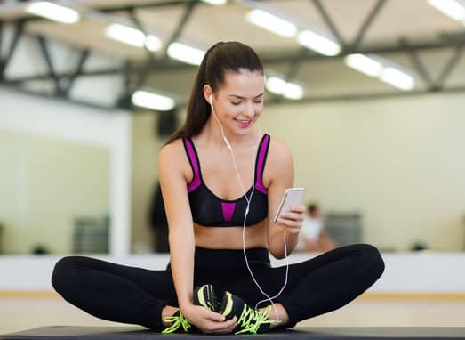 smiling woman stretching on mat in the gym