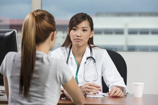 Asian doctor talking with female patient
