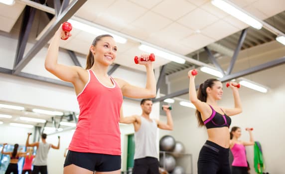 group of people working out with dumbbells