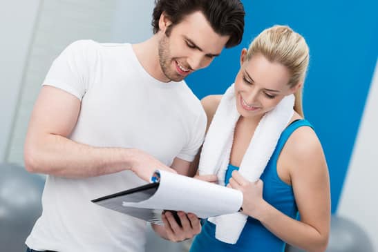 Young woman talking to her fitness trainer