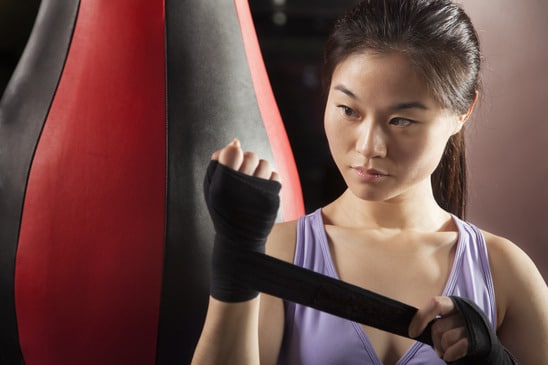 photodune-8811500-young-confident-female-boxer-wrapper-her-wrists-in-the-gym-xs