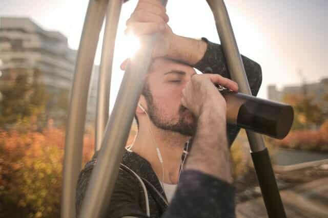 tired-sportsman-man-drinking-water-during-training-on-street-3771085